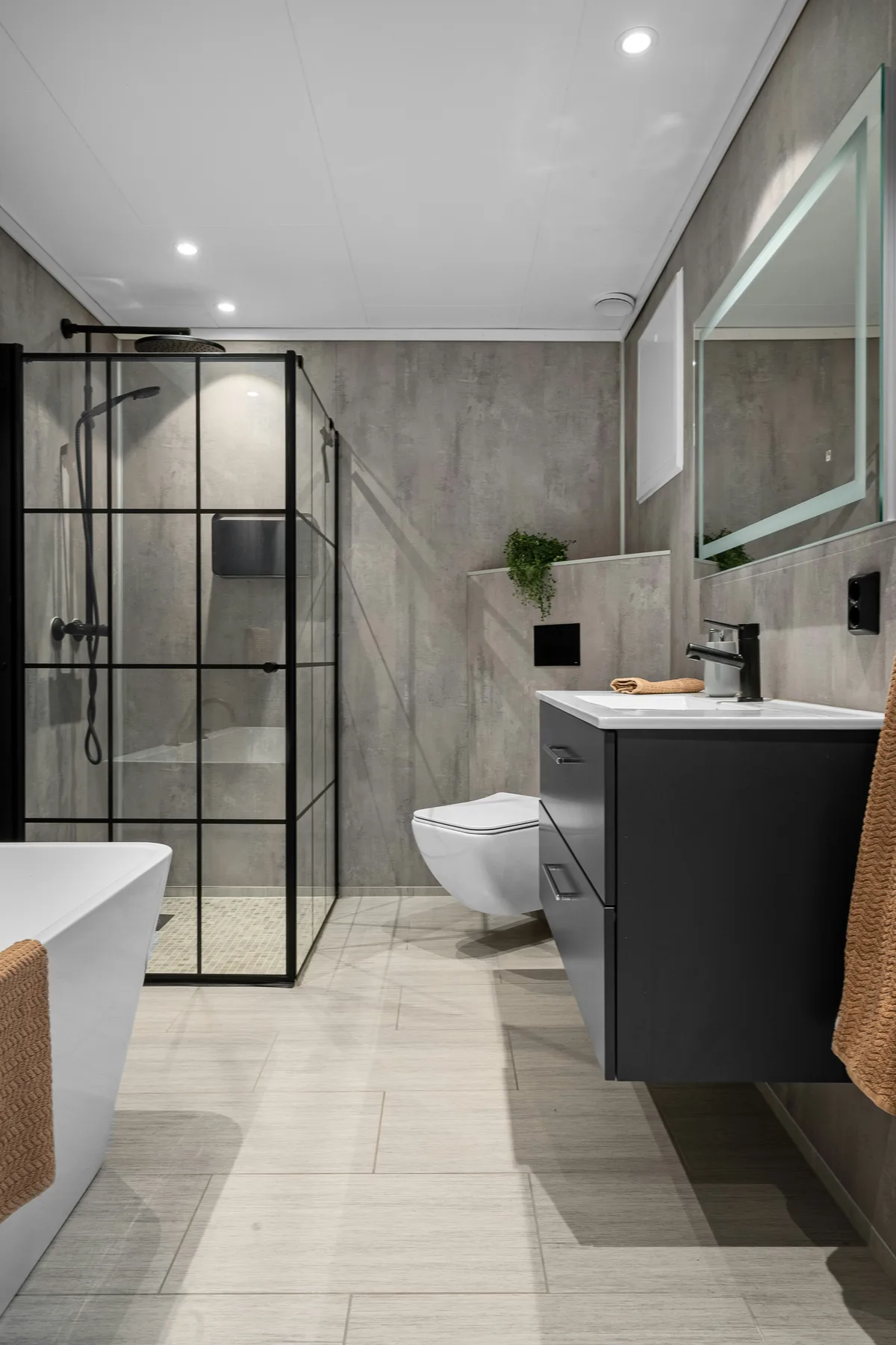 Modern grey bathroom renovation with walk-in shower and freestanding bath
