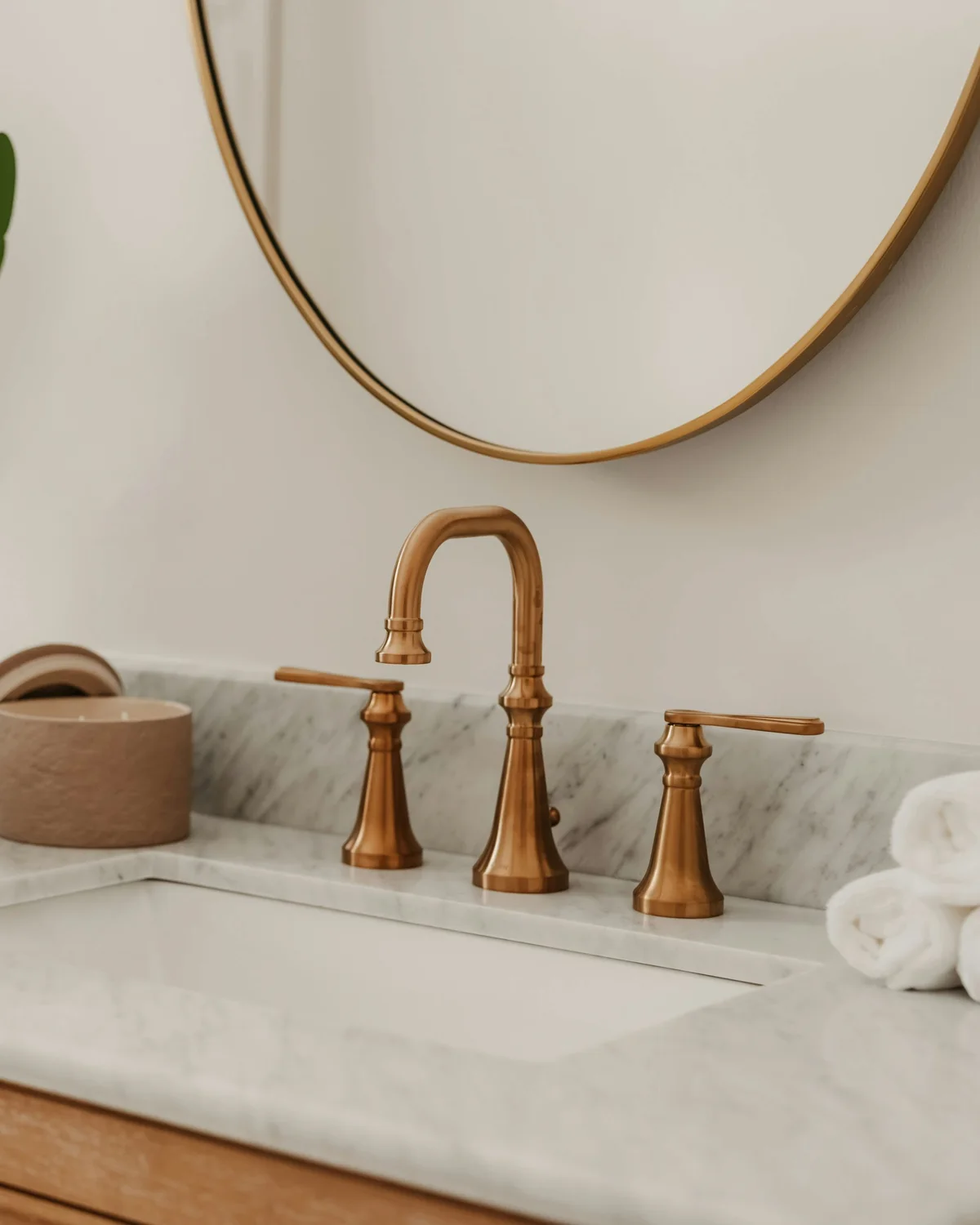 Bespoke bathroom renovation — Carrara marble vanity with brushed-brass widespread tap and gold-framed mirror